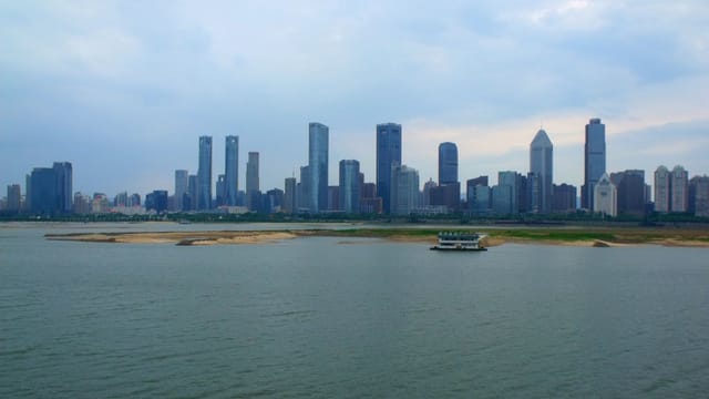 Panoramic view of Nanchang's skyline across the harbor with modern skyscrapers and river.