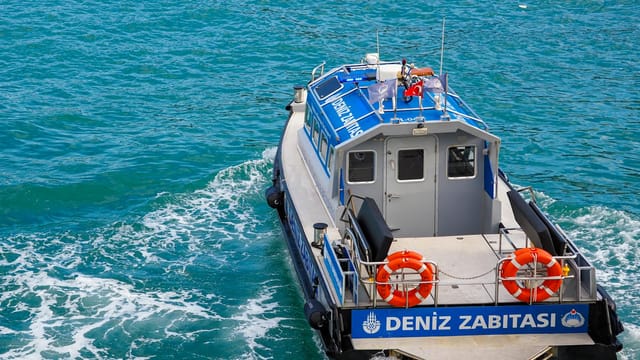 Marine patrol boat cruising the vibrant waters of Istanbul, Turkey with clear blue sea and lifebuoys onboard.
