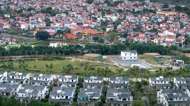 Drone view modern residential cottages located on grassy suburb district of modern town on summer day