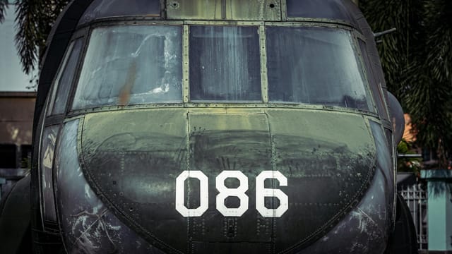 A close-up view of a vintage military helicopter on display outdoors.