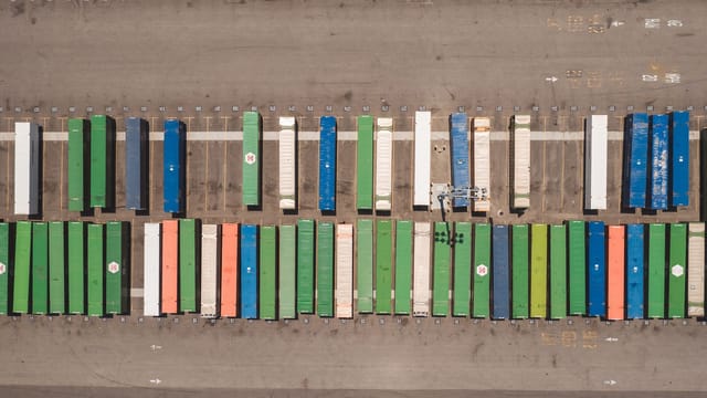 Top view of neatly arranged cargo containers in a shipping port, highlighting logistics and global trade.