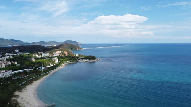 Explore the scenic coastal beauty of Sanya, Hainan with its sandy beaches and lush greenery.