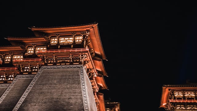 A stunning night view of a traditional Chinese pagoda, beautifully illuminated and towering under the night sky.