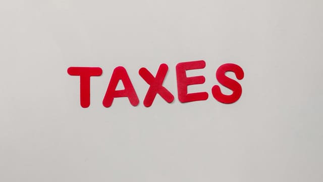 Simple and bold image of the word taxes in red letters on a white background.