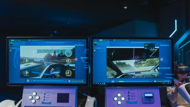 Immersive virtual reality gaming experience with dual screens and VR headsets, featuring driving simulations.