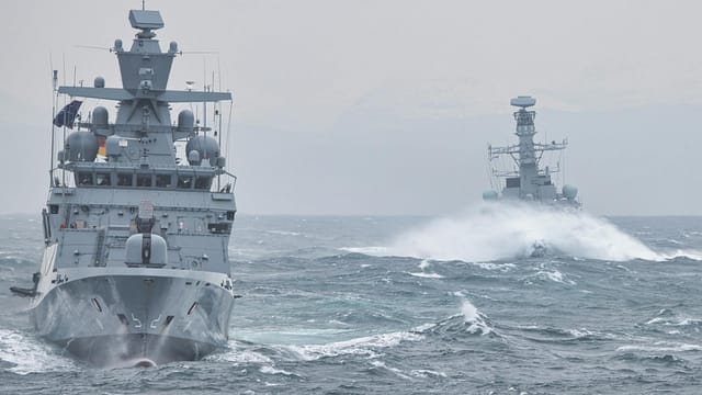 Navy warships navigating turbulent ocean waters showcasing maritime strength.