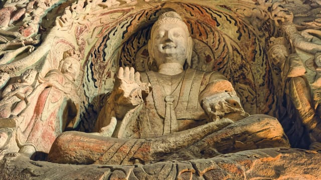Explore the serene Buddha sculpture in China's historic Yungang Grottoes.