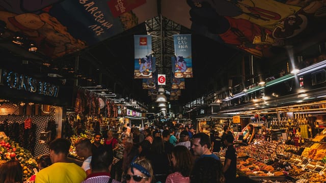 Vibrant and bustling scene from a crowded market in Barcelona, Spain showcasing lively shopping and diverse foods.