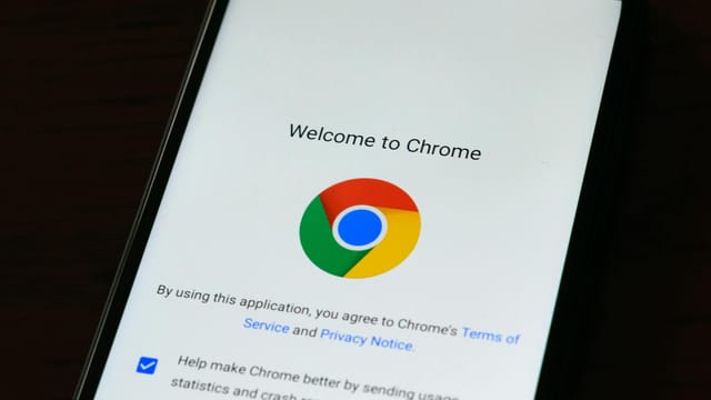 Close-up of smartphone displaying Google Chrome's welcome page and logo.