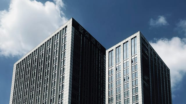 Tall skyscrapers with modern architecture reaching into a clear blue sky.