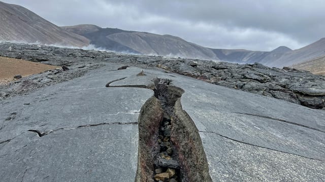 A cracked volcanic landscape near Reykjavík, Iceland showcasing rugged terrain and dramatic geology.