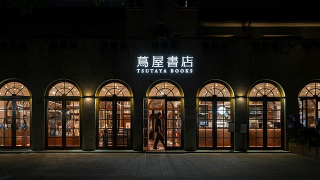 Evening view of the elegant Tsutaya Books storefront with warm lighting and inviting atmosphere.