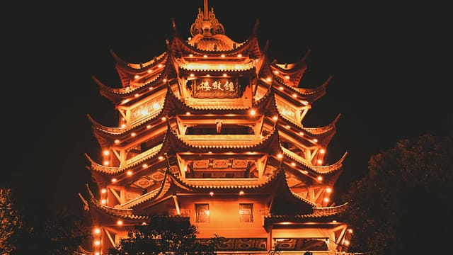 Beautifully illuminated traditional Chinese pagoda at night in Sichuan, China, showcasing intricate architecture.