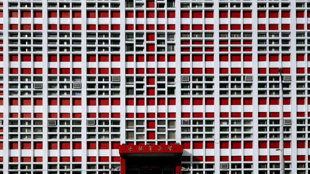 A striking red and white geometric facade of a building in Taipei City, showcasing modern minimalist design.