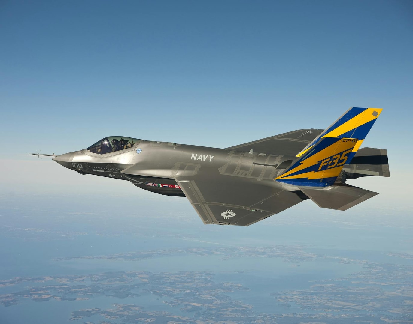 Stunning aerial view of a Navy F-35 fighter jet soaring through clear skies.