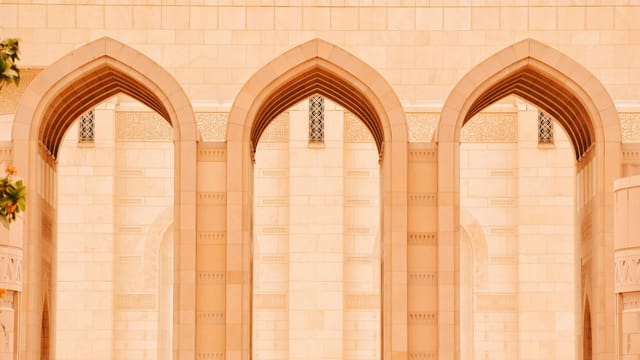 Close-up of elegant arches at the Sultan Qaboos Grand Mosque in Muscat, Oman.