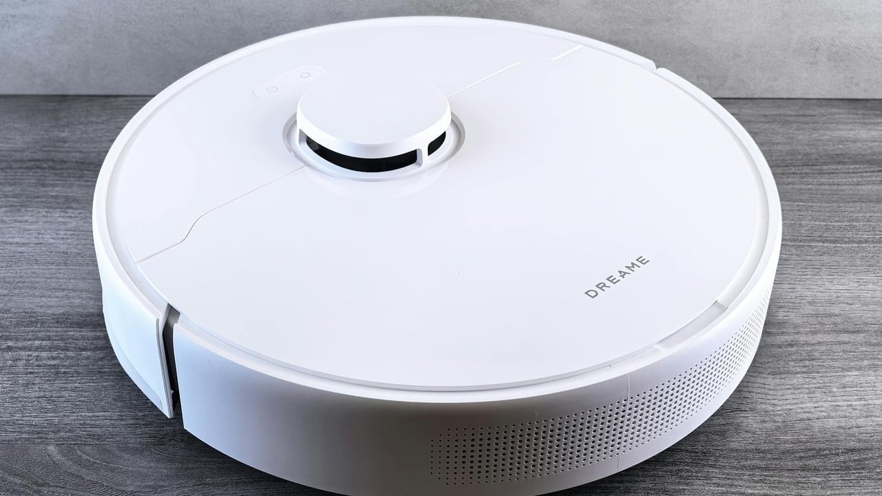 High-angle view of a sleek white robotic vacuum cleaner on a wooden floor, perfect for smart home setups.