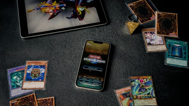 Yu-Gi-Oh cards displayed with tablet and phone, featuring Duel Links game.