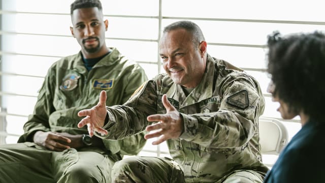 A group therapy session with military veterans discussing recovery and support.
