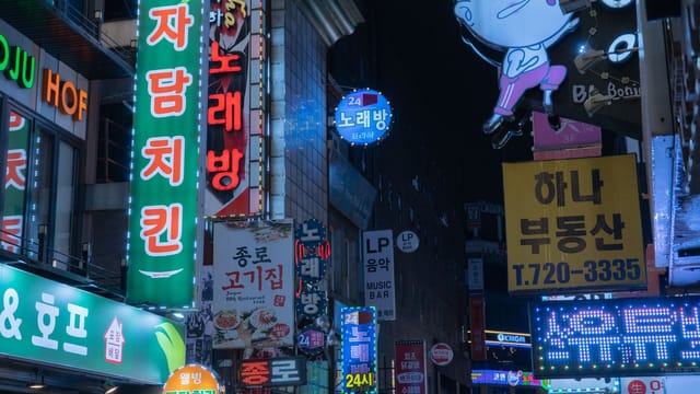 Bright neon lights and bustling night scene in downtown Seoul, Korea.