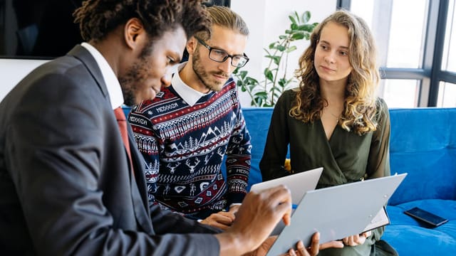 A diverse group of young professionals engaged in a business meeting inside a modern office.