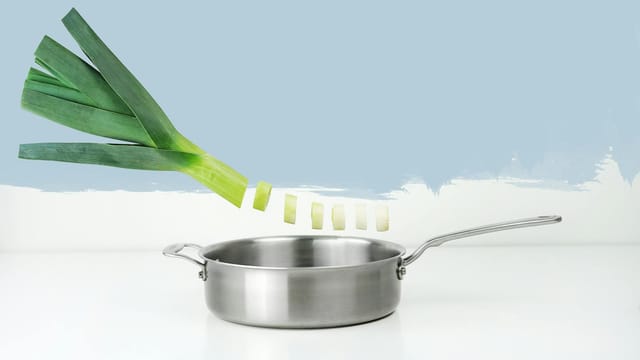 Artistic image with leek and stainless steel pan in minimalist style.