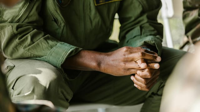 Focused image of a soldier's hands in uniform, symbolizing military pride and service.