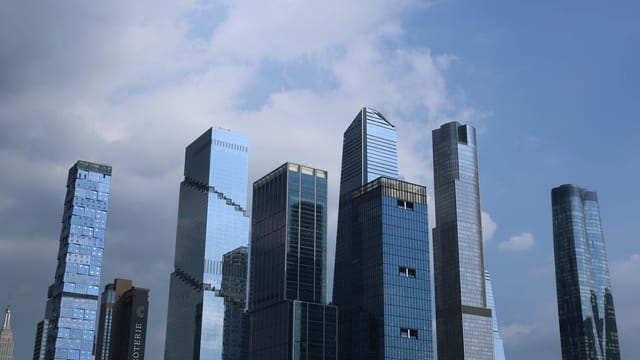 Skyline view of modern skyscrapers under a blue sky in New York City.