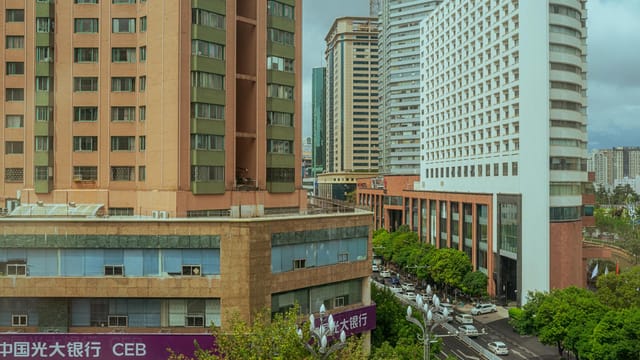 Panoramic view of a busy city street lined with modern high-rise buildings.