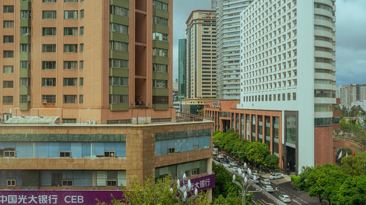 Panoramic view of a busy city street lined with modern high-rise buildings.