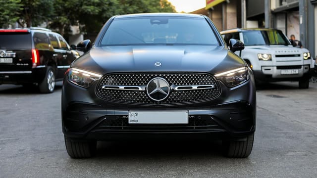 Front view of a sleek Mercedes-Benz SUV in a city setting, showcasing luxury in Amman, Jordan.