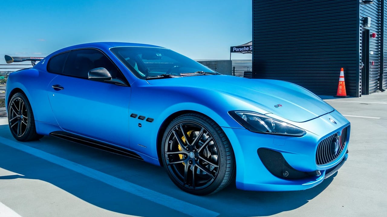 A sleek blue Maserati sports car parked at a modern garage in Orlando.