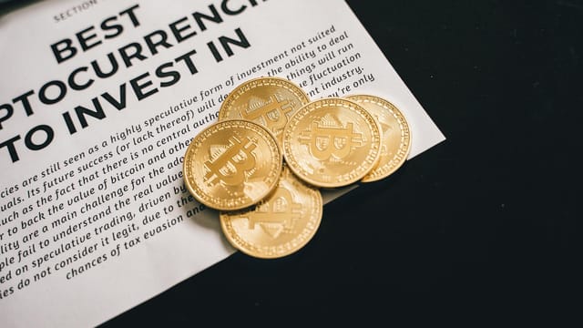 Close-up of Bitcoin coins on investment document promoting cryptocurrencies.