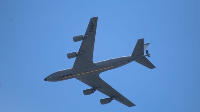 Aerial view of a USAF aircraft flying in a clear blue sky, showcasing aviation design.