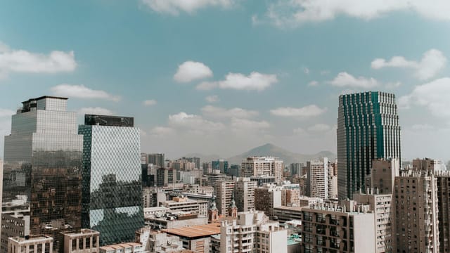 View of Santiago's skyline featuring modern architecture and surrounding mountains under a clear sky.
