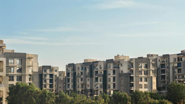 Modern residential buildings with greenery under clear blue sky