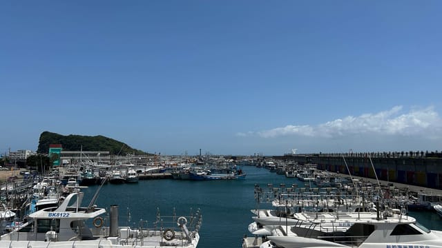 Bright summer day at Nanfang'ao Fishing Harbor with moored boats and clear blue sky.
