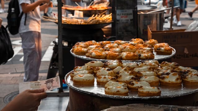 Explore the bustling street food scene in Seoul with delicious pastries on display.