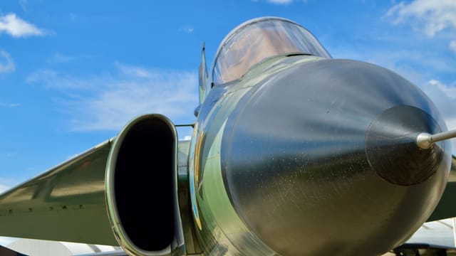 Detailed shot of a military jet nose cone in Madrid under clear skies.