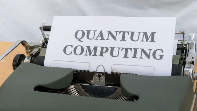 A vintage typewriter with a paper displaying the term Quantum Computing.