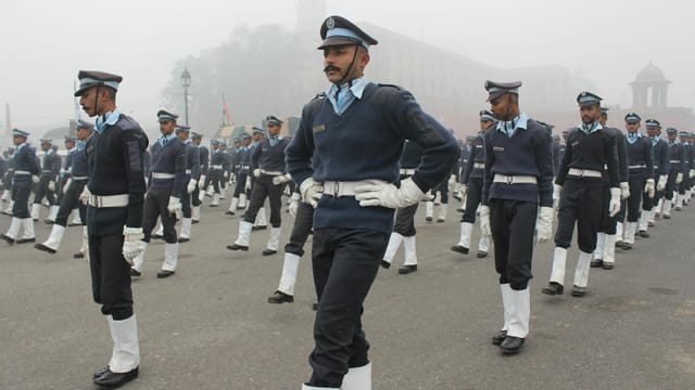 Indian military personnel marching in uniform during a foggy independence day parade.
