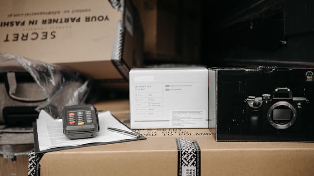 Assorted packages with camera equipment ready for shipment in an indoor setting.
