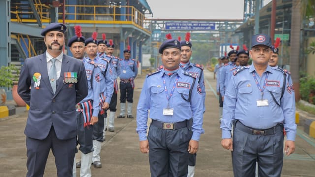 Group of Indian security personnel in blue uniforms standing in formation outdoors.