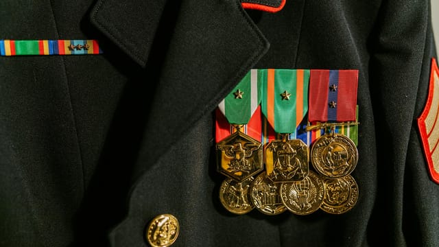 Close-up of a military uniform adorned with various medals of recognition and honor.