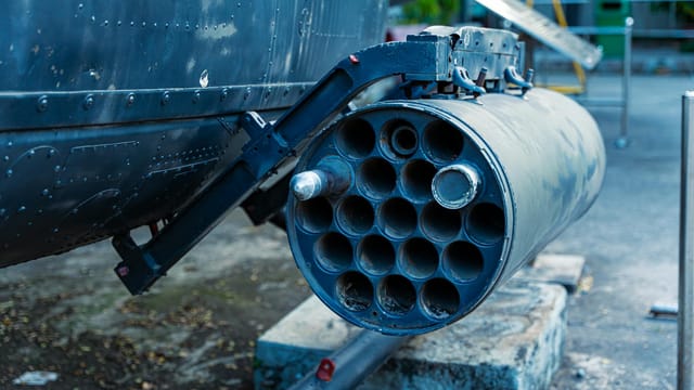 Detailed view of a military rocket launcher showcased outdoors, showcasing industrial design.