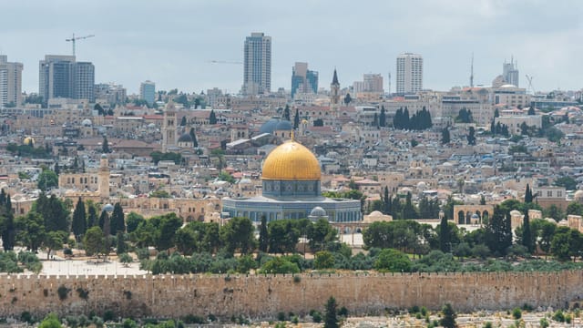 Captivating aerial view of the Dome of the Rock with Jerusalem's skyline in the background.