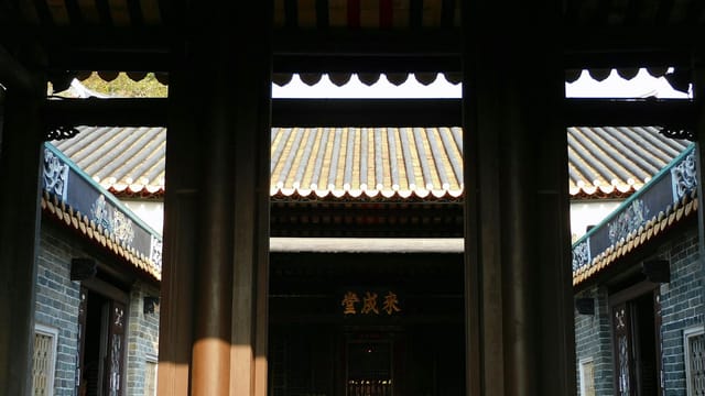 Gate leading to yard of ancient Buddhist shrine on sunny day in Hong Kong