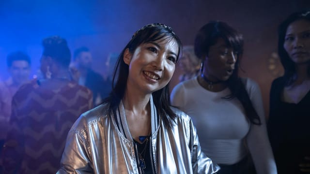 A lively night out at a club featuring women enjoying music and colorful lights.
