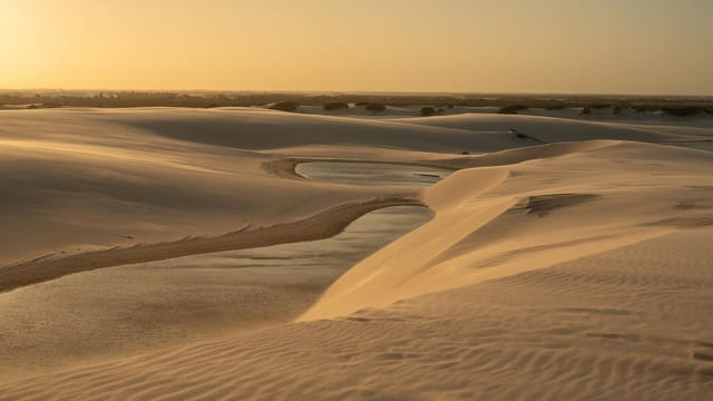 Golden sunset over tranquil sand dunes in Brazil's stunning landscape.