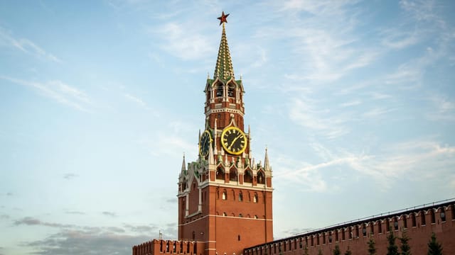 The iconic Spasskaya Tower of the Moscow Kremlin under a beautiful evening sky.